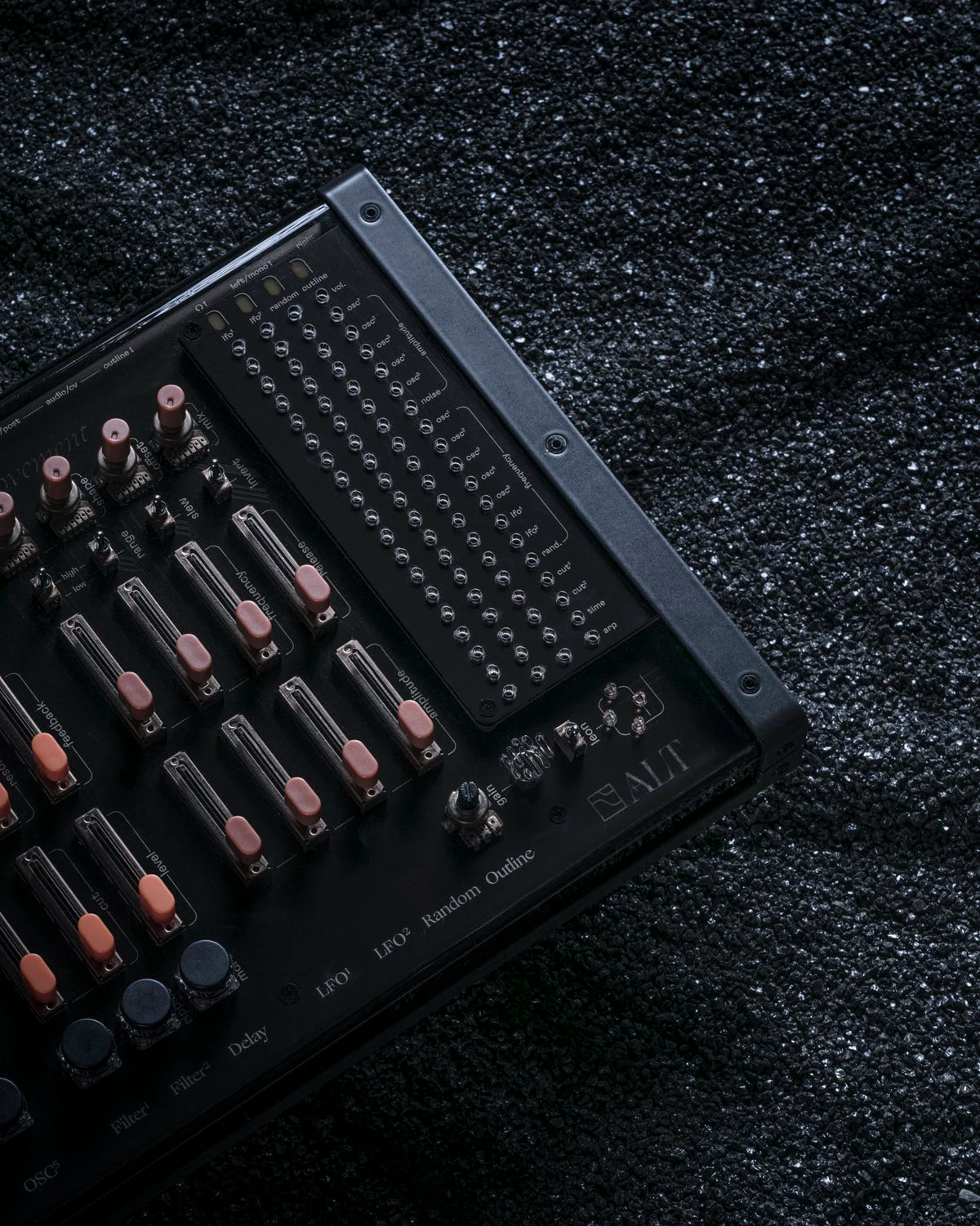 ALT synthesizer lying on black sand